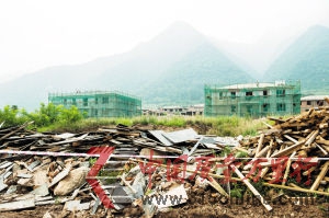 圖為:在秦嶺北麓圭峰山腳下原“優(yōu)勝美地”別墅區(qū)已拆除的違章別墅廢墟之上,新的開(kāi)發(fā)商已經(jīng)開(kāi)始對(duì)部分未拆除別墅進(jìn)行外觀改造(8月9日攝)。